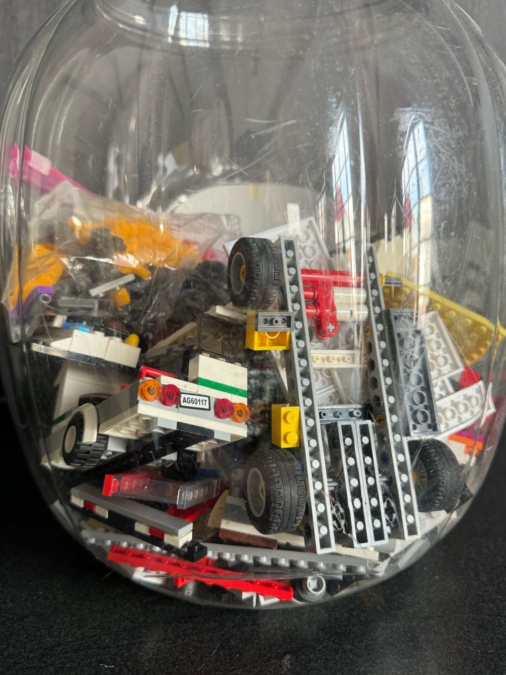 Large canister of Legos including Legos with wheels and vehicles